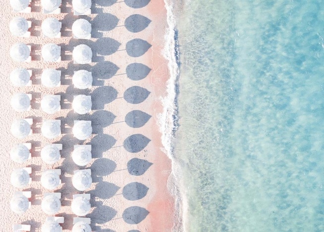 – Poster of a beach containing sunbeds and parasols 