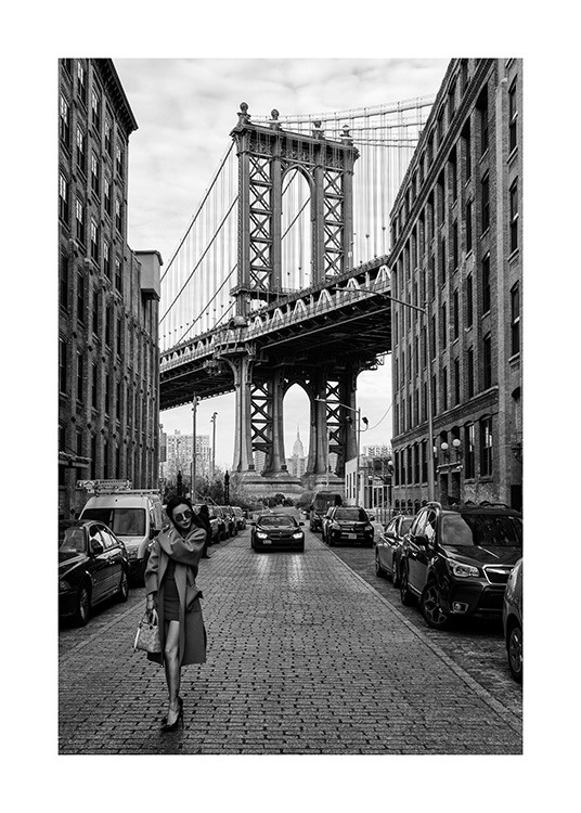  – Black and white photograph of a woman standing in a street in New York in front of Manhattan Bridge