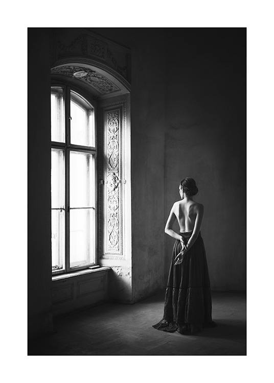 Black and white photograph with woman wearing black skirt in front of big window
