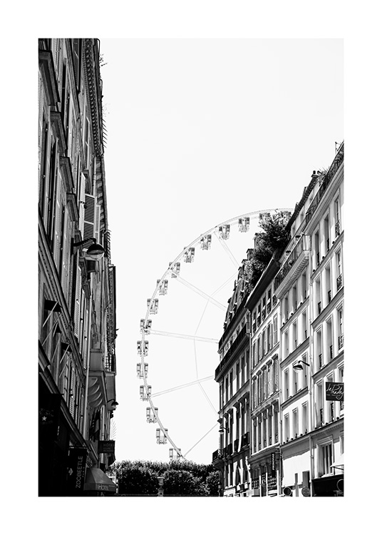  - Black and white photograph of a ferris wheel in Paris with house facades in front