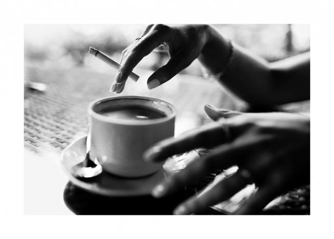  - Black and white photograph of a coffee cup and hands holding a cigarette