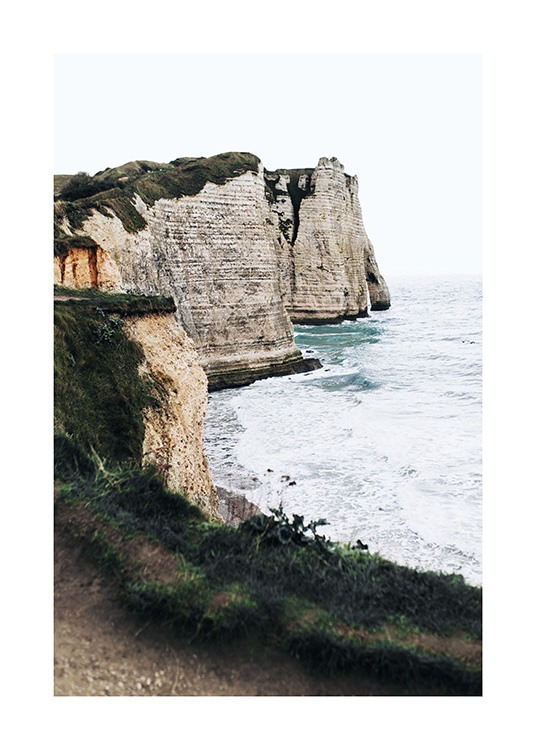  – Photograph of a stormy ocean and tall cliffs with green grass on top of them