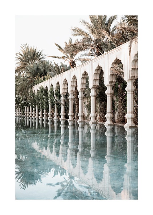  - Photograph of white pillars and curved arches next to a pool with palm trees in the background