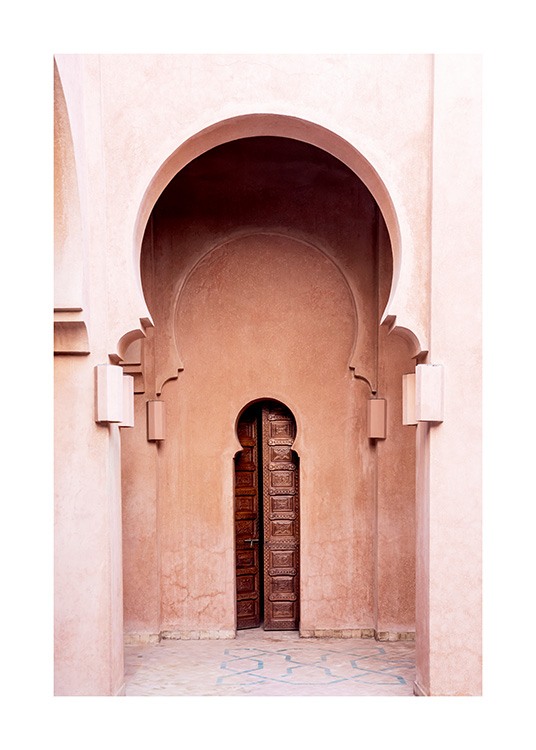  - Photograph of a pink building with curved arches and a narrow, brown door in the middle