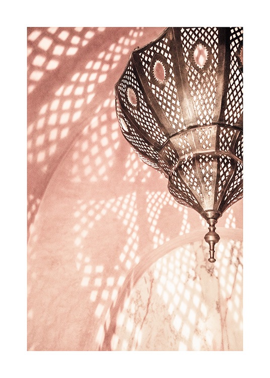  - Photograph of a pink room with a metal lamp reflecting a pattern on the walls