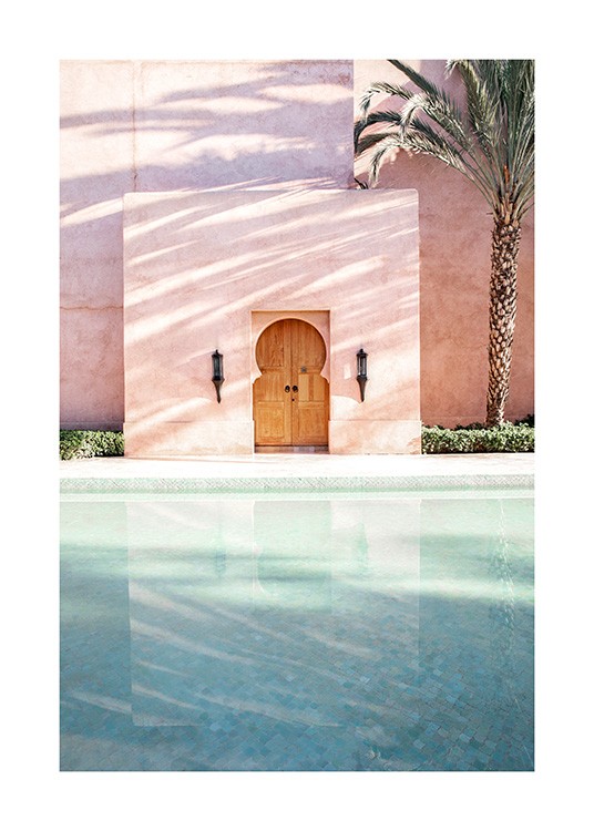  - Photograph of a palm tree next to a pink building with a pool in front of it