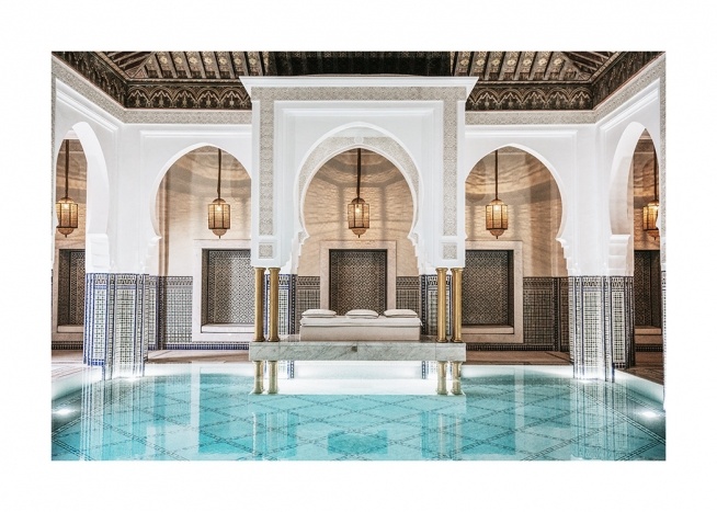  - Photograph of a room with golden lamps, white, curved arches and a pool