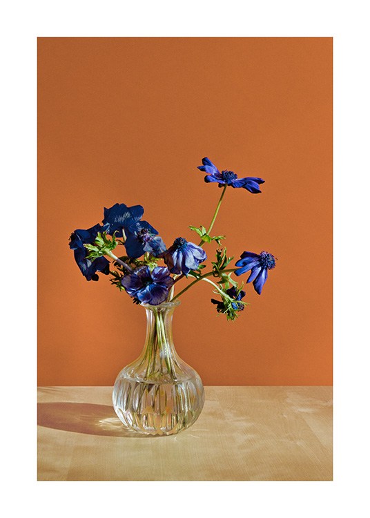  – Photograph of a vase with blue flowers in front of an orange wall
