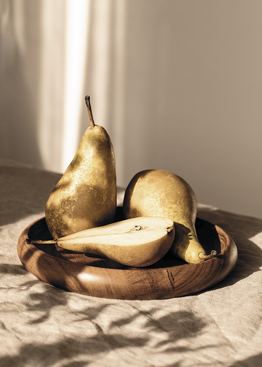  – Photograph of three pears laying in the sun on a wooden plate