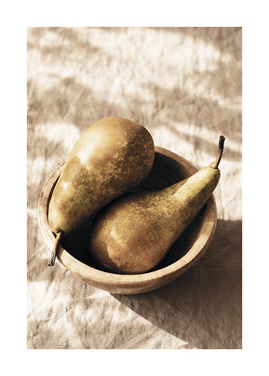  – Photograph of a pair of pears laying in a wooden bowl on a beige linen cloth