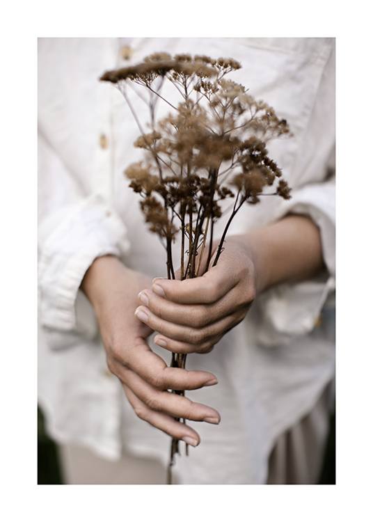  – Photograph of a woman holding a bouquet with dried flowers, with her white linen shirt in the background
