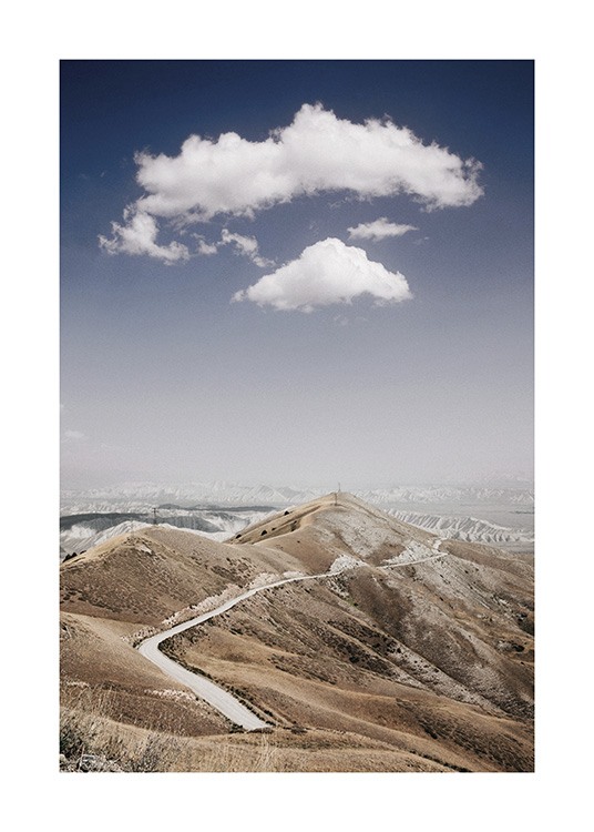  – Photograph of a mountain range with a road through it, with clouds and a blue sky in the background