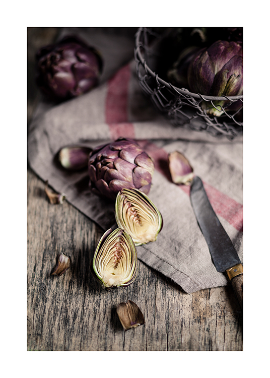  – Photograph of sliced pieces of artichokes and a knife laying on a linen cloth on a wooden table