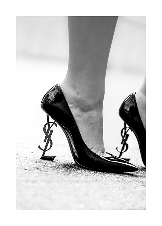  – Black and white photograph of a pair of heels with the YSL logo as the heel