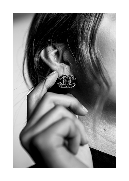  – Black and white photograph of a woman with a Chanel earring lightly touching her ear