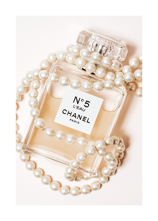  – Photograph of a perfume bottle with Chanel No5 written on it, wrapped in a white pearl necklace