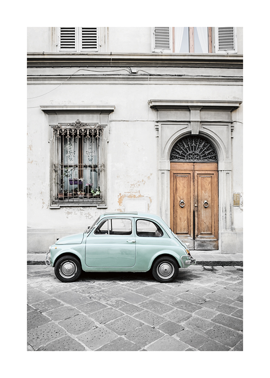  – Photograph of a mint green vintage car outside of an old, grey building
