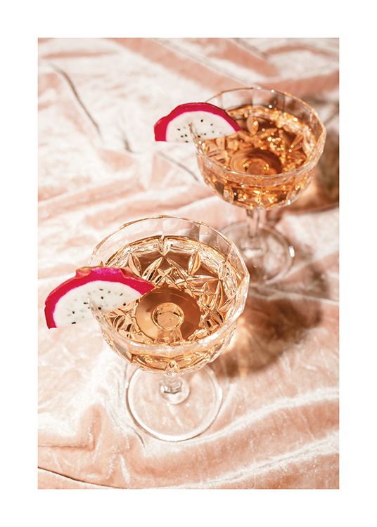  – A photograph of two rosé champagne cocktails in crystal glasses with dragonfruit slices