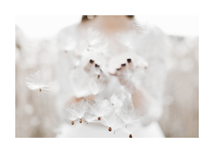  – Photograph of a bunch of flying dandelion seeds with a woman in the background