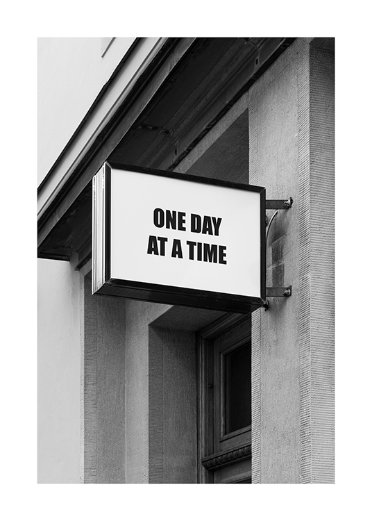  – Black and white photograph of a sign with text on a building