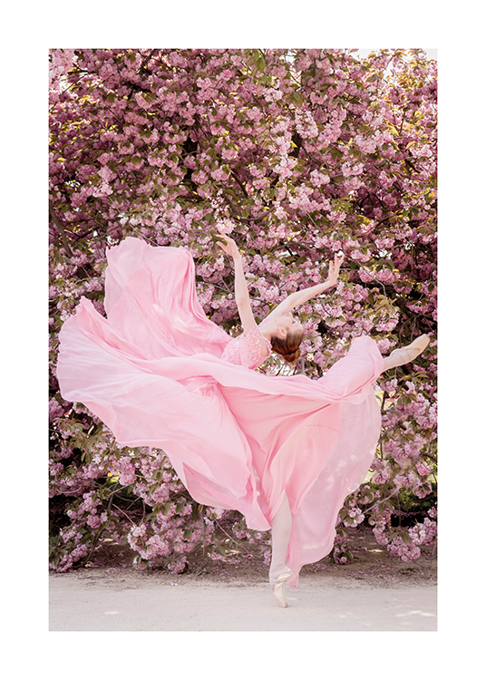 – Photograph of a ballerina wearing a pink dress, doing a dance pose in front of a pink flower wall