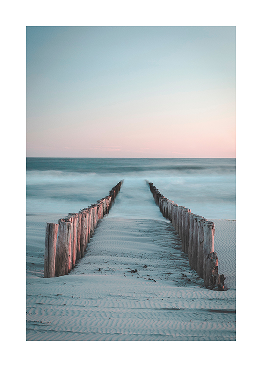 – Photograph of a two rows of wooden poles going from the beach into the ocean covered in fog