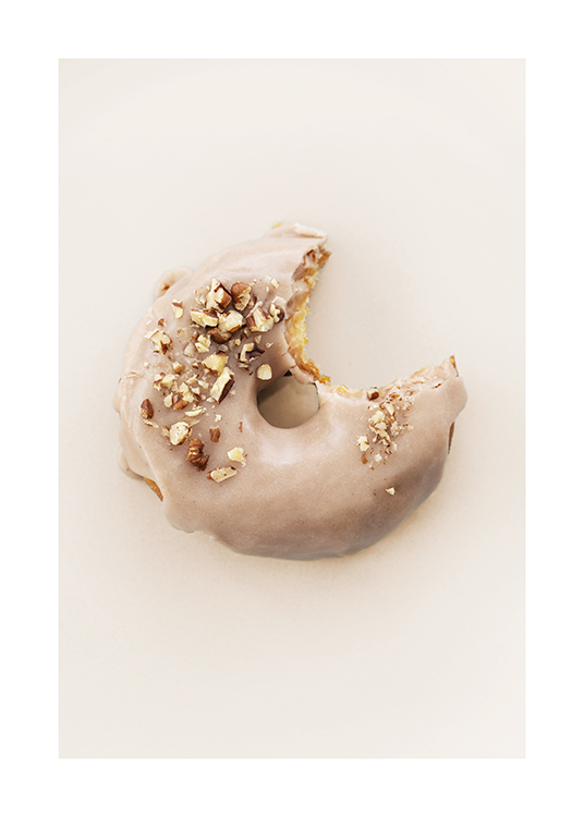  – Photograph of a donut with beige frosting and nut topping