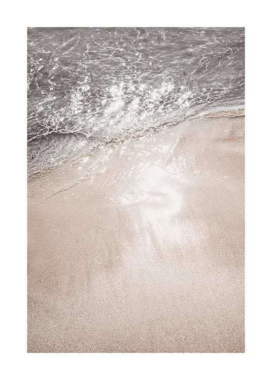  – Photograph of glimmering ocean water coming onto the sand beach