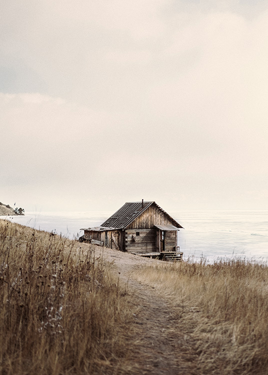 – A landscape photograph of a brown cabin by the sea