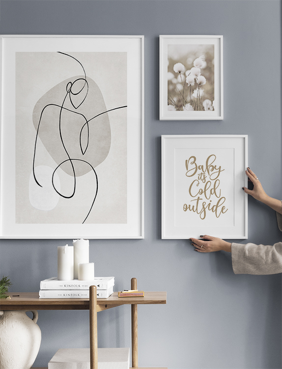 A calm gallery wall with quotes, photographs and illustrations in nature colours for the hallway
